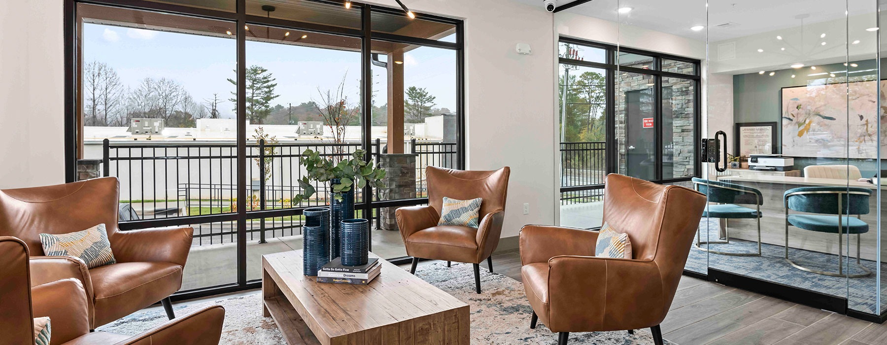 a lounge with chairs table and windows